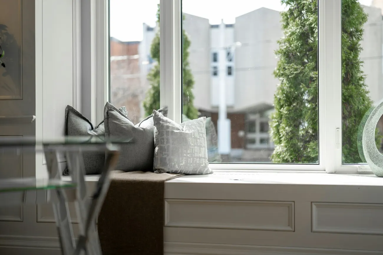 Fensterbank mit zwei Kissen vor großen Fenstern