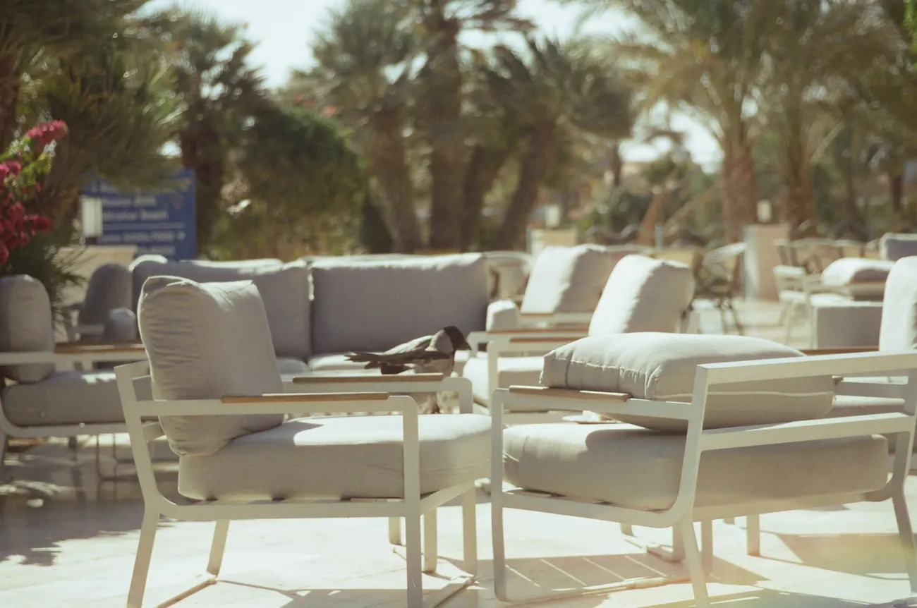 Weiße Lounge-Möbel mit Auflagen auf einer sonnigen Terrasse