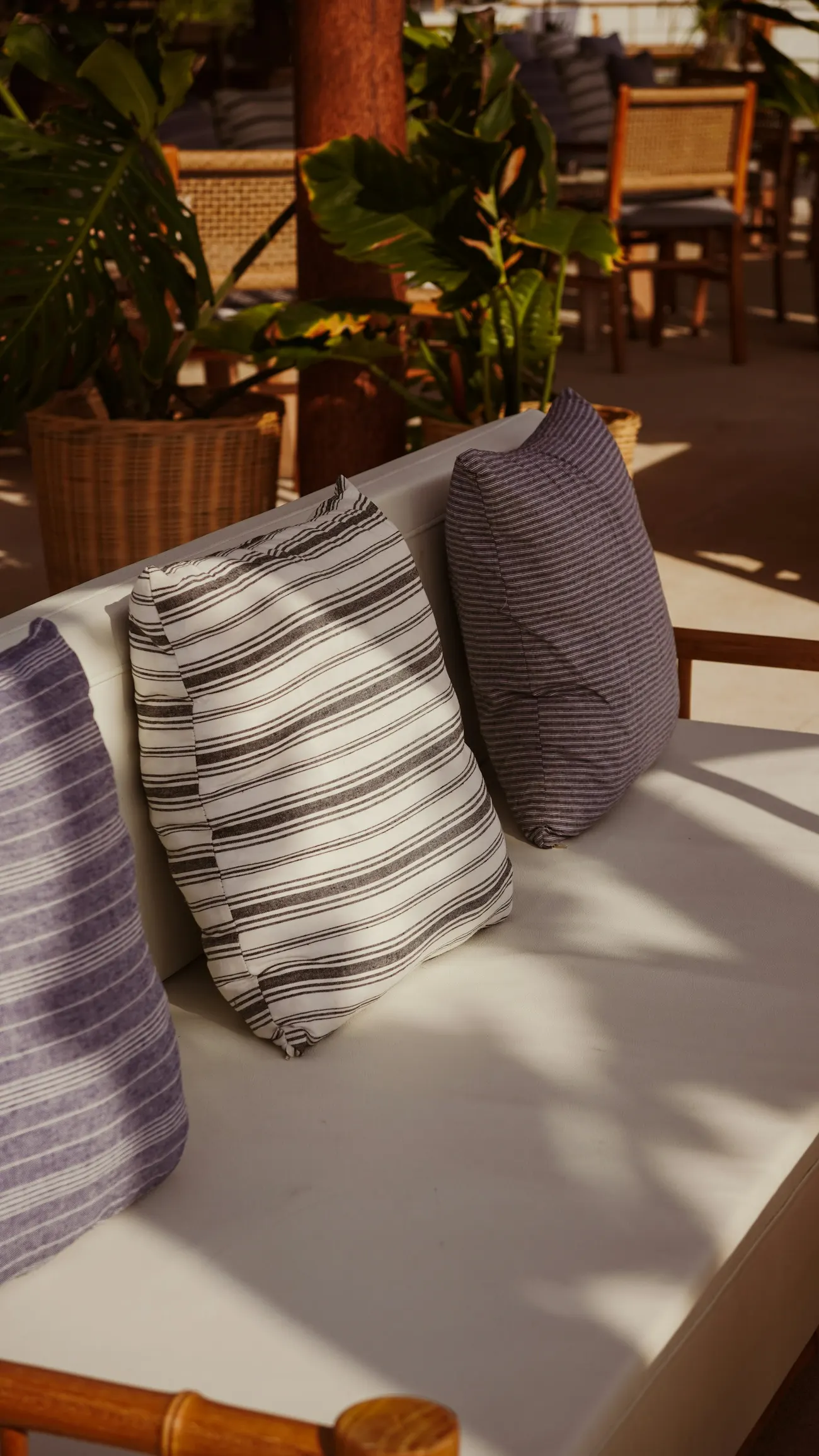 Lounge im Freien mit gestreiften Kissen und Pflanzen