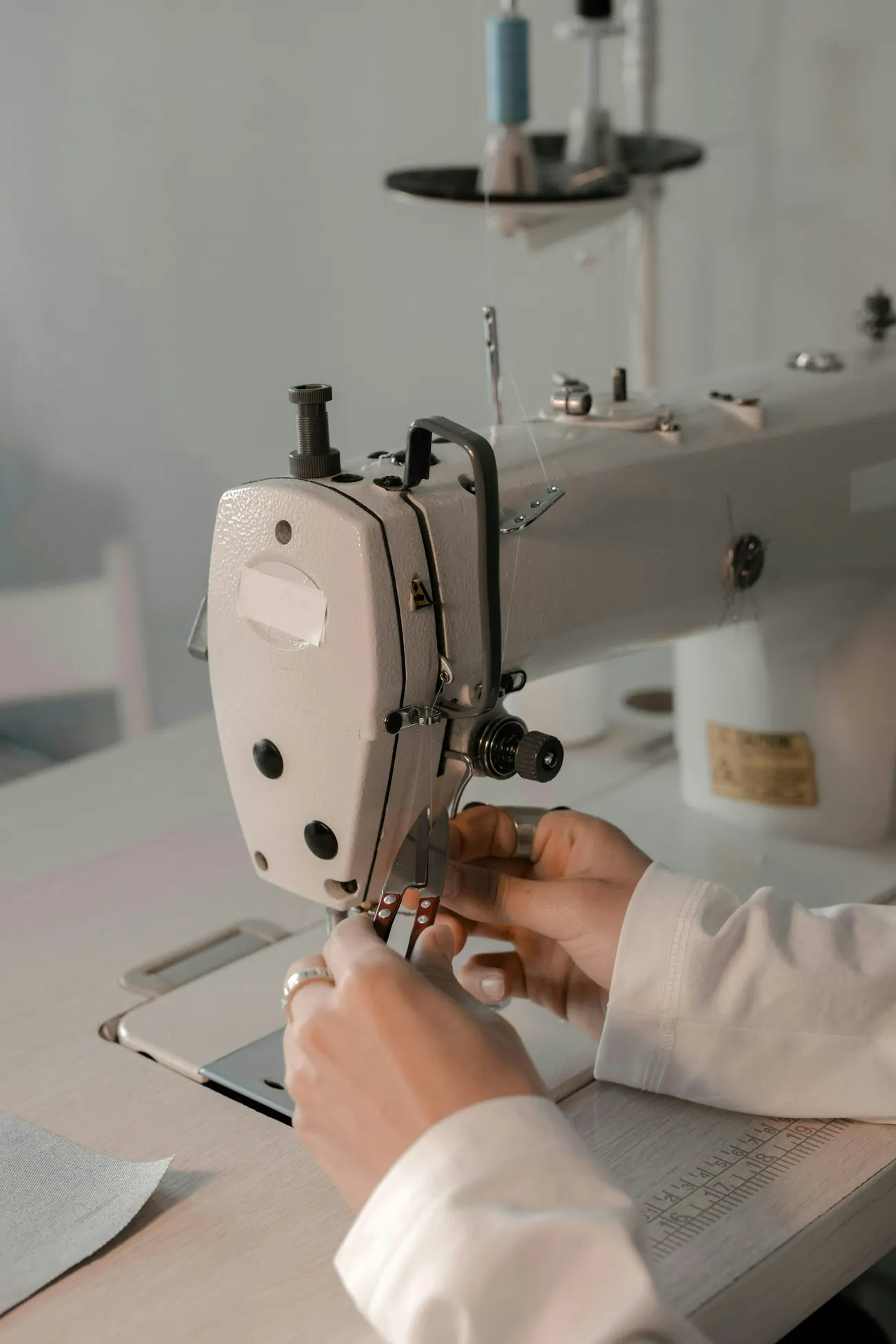 Hände führen Stoff an einer Industrienähmaschine